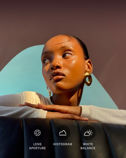 Grande plano de um modelo bem iluminado contra um fundo colorido, para ilustrar a interface de utilizador dos controlos profissionais do sistema de câmaras Pro: abertura, histograma e balanço de brancos